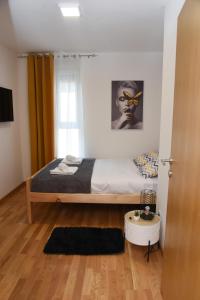 Millenium apartment في سوكو بانيا: غرفة نوم بسرير مع اطار خشبي