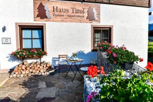 a building with a table and flowers in front of it at Haus Tirol Ehrwald in Ehrwald