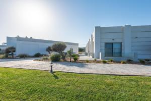 a large white building with a lawn in front of it at Royal Bay Suites in Kefalos