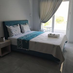 sypialnia z dużym łóżkiem i oknem w obiekcie Mei's luxury apartments w Stavrós