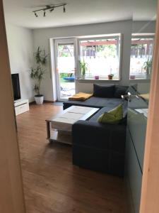 uma sala de estar com um sofá e uma mesa em Ferienwohnung Fügner em Bad Schussenried