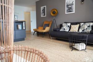 salon z czarną kanapą i krzesłem w obiekcie Top 19 Alpe Maritima - Luxury Lakeview Apartment w mieście Annenheim