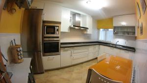 uma cozinha com armários brancos e electrodomésticos de aço inoxidável em CALLE LOBO 17 em Luarca