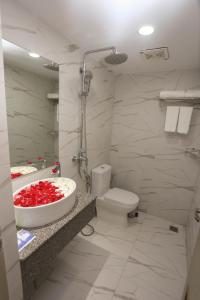 a bathroom with a sink and a toilet and a tub at Yangon Win Hotel in Yangon