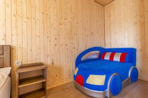 a bed in a room with a blue chair at ROMANTIK in Solotvyno