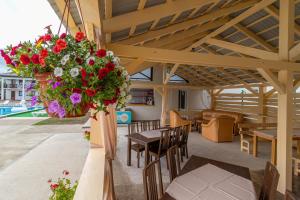 a patio with a table and chairs and flowers at ROMANTIK in Solotvyno