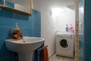La salle de bains est pourvue d'un lavabo et d'un lave-linge. dans l'établissement Appartamento nel centro storico di Sciacca, à Sciacca