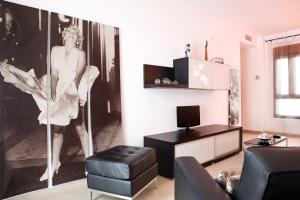 a living room with a picture of a woman on the wall at Real de Cartuja Apartments & Suites in Granada