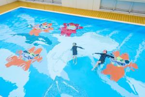 a pool with two people on top of a map of the world at Hotel Ocean (Kokusai-Dori) in Naha