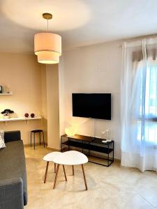 uma sala de estar com um sofá e uma televisão de ecrã plano em Ideal Apartamento - Guadalest em Guadalest