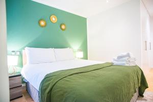 a bedroom with a bed with two clocks on the wall at One Bed Serviced Apt in Farringdon in London