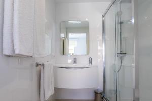 a white bathroom with a sink and a mirror at MEVAMAR in Fornells +24 photos