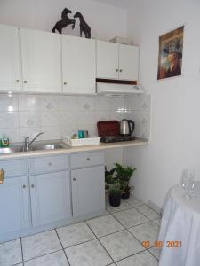 una cucina con armadi bianchi e lavandino di Studios Anais - Thasos a Limenas