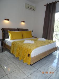 een slaapkamer met een groot bed met gele kussens bij Studios Anais - Thasos in Limenas