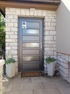 einer Haustür eines Hauses mit zwei Topfpflanzen in der Unterkunft Danijela Rovinj sea view and free parking in Rovinj