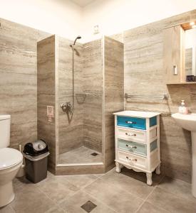 y baño con ducha, aseo y lavamanos. en Stratos by mRoom Apartments en Makry Gialos