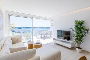 a living room with a white couch and a television at MEVAMAR in Fornells