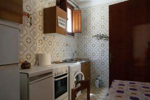 Il comprend une petite cuisine équipée d'un four avec plaques de cuisson blanches. dans l'établissement Appartamento nel centro storico di Sciacca, à Sciacca