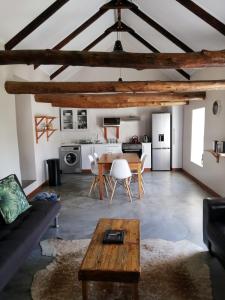 a living room with a couch and a table at Treyntjes Rivier Cottages in Caledon