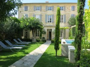 a building with lounge chairs and a swimming pool at La Maison Saint Jean in Boulbon