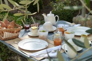 einen Tisch mit Tellern und Tassen und eine Teekanne in der Unterkunft La Maison Saint Jean in Boulbon
