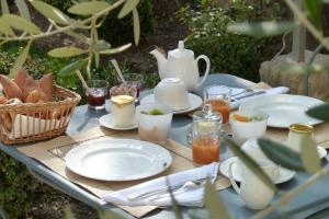 - une table avec des assiettes et des tasses ainsi qu'une théière dans l'établissement La Maison Saint Jean, à Boulbon