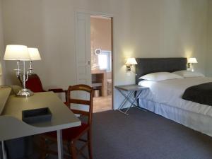 una camera d'albergo con letto, tavolo e scrivania di La Maison Saint Jean a Boulbon