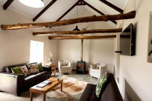 a living room with a couch and a fireplace at Treyntjes Rivier Cottages in Caledon