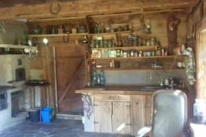 a kitchen with wooden cabinets and a counter with a chair at Molfar, Beskid Niski , połowa domu in Polany