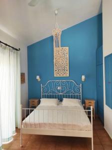 a blue bedroom with a bed with a blue wall at Lontos Village in Finikounta
