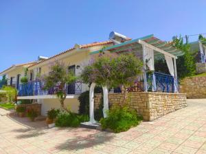 a house with a porch and a stone wall at Lontos Village in Finikounta