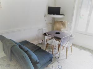 a living room with a couch and a table at Doux Ombrages in La Bourboule