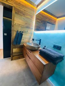 ein Badezimmer mit einem Spülbecken auf einer Holztheke in der Unterkunft Kitz Kaiser Appartement in Sankt Johann in Tirol