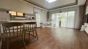 a kitchen with two chairs and a table in a room at Jeju Time-Travel Pension in Jeju