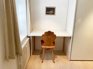 a wooden chair sitting under a desk in a room at Alpenstil - 60m2 Dachstockwohnung mit Garage - BM186 in Pontresina