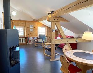 Cette chambre dispose d'une mezzanine avec un bureau et une table. dans l'établissement Dachwohnung im Alpenstil, 60m2 für 2P, mit Garage - BM186, à Pontresina