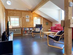 sala de estar con sofá rojo y sillas en Dachwohnung im Alpenstil, 60m2 für 2P, mit Garage - BM186 en Pontresina