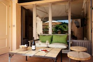a patio with a table with wine glasses and a couch at Casa Maitetxu 2 in Puente la Reina