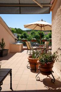eine Terrasse mit einem Tisch, einem Sonnenschirm und Pflanzen in der Unterkunft Casa Maitetxu 2 in Puente la Reina