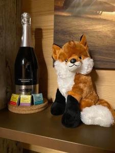 ein ausgestopfter Fuchs auf einem Regal neben einer Flasche Wein in der Unterkunft Apartment Fuchsbau in Lachtal