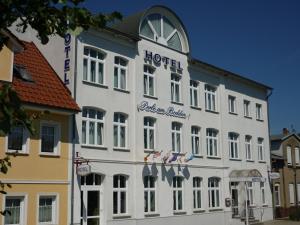 a large white building with a hotel sign on it at Apartment-Hotel Perle am Bodden in Ribnitz-Damgarten