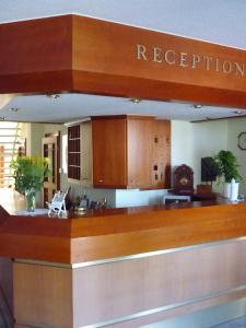 a restaurant with a counter with a reception desk at Hotel Perle am Bodden in Ribnitz-Damgarten