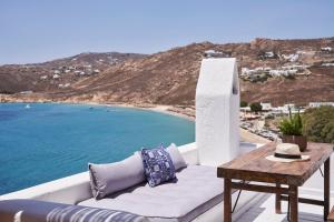 a white couch sitting on a balcony overlooking the ocean at Boheme Beach Houses in Elia Beach +26 photos