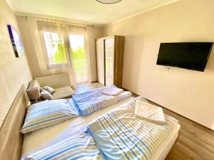 A bed or beds in a room at Unio Vendégház 1