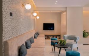 a lobby with chairs and a wall with a tv at Katerina Palace Hotel in Argassi