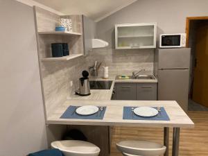 kuchnia z blatem z dwoma białymi talerzami w obiekcie Apartman Turanj w mieście Turanj +37 zdjęć