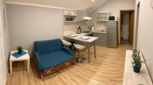 mała kuchnia ze stołem i niebieskim krzesłem w obiekcie Apartman Turanj w mieście Turanj