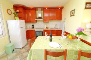 uma cozinha com uma mesa e um frigorífico branco em Apartments Stipo em Drače