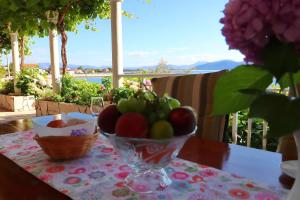 een kom fruit op een tafel met een tafelkleed bij Apartments Stipo in Drače