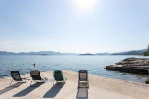een groep stoelen op de rand van een waterlichaam bij Apartments Stipo in Drače